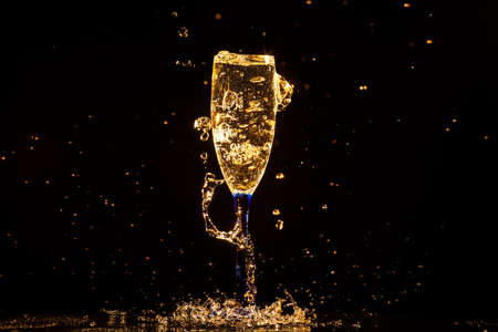 Champagne pouring in glass on a black backgroundの写真素材