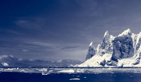 Beautiful snow-capped mountains against the blue sky in Antarcticaの写真素材