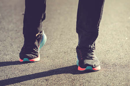 Runner athlete legs running on the road. Sunset lightの写真素材