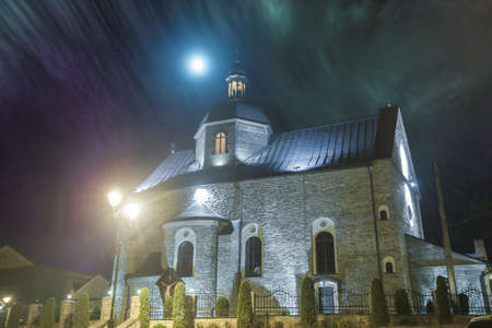 The beautiful medieval church in the night light and fogの写真素材