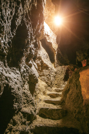 looking inside rock cave. stairs in rock cave with sunlightの写真素材