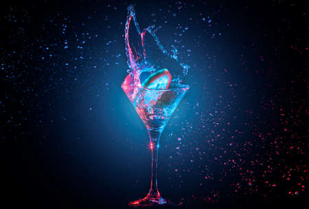 Bright cocktail with lemon in glass and splashing water on dark backgroundの写真素材