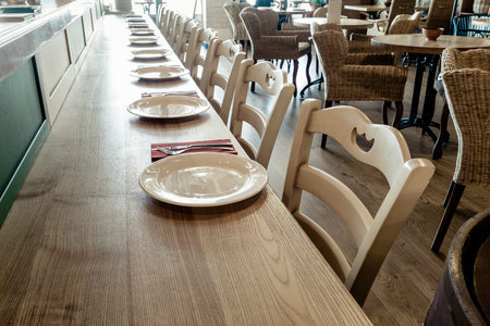 long wooden table decorated with dishware for banquet