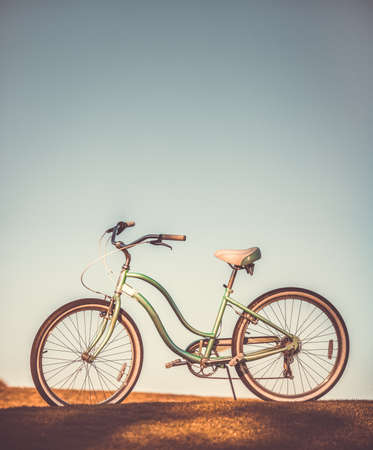 Old retro bicycle on earth and grey sky backgroundの写真素材