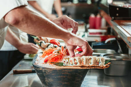 male cooks preparing sushi in the restaurant kitchenの写真素材