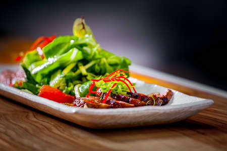 Delicious appetizer with herbs and meat on white plate close upの写真素材