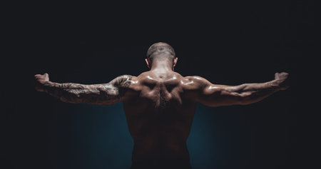 muscular male Bodybuilder posing in studio over blackの写真素材