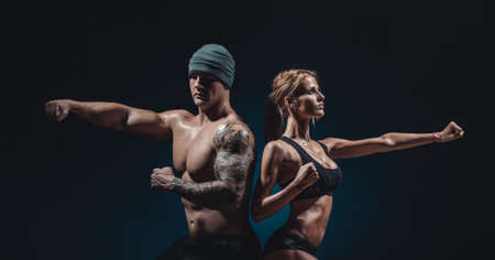 beautiful athletic man and woman posing on black backgroundの写真素材