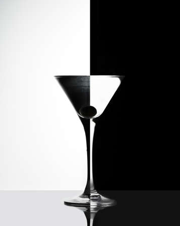 Transparent Glass with liquid and olive on black and white backgroundの写真素材