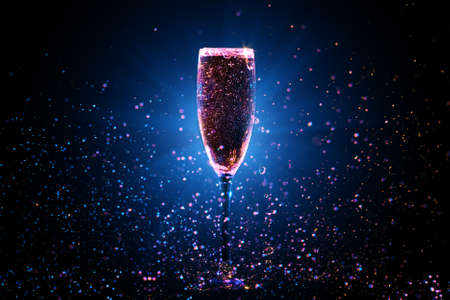 Champagne pouring in glass on black backgroundの写真素材