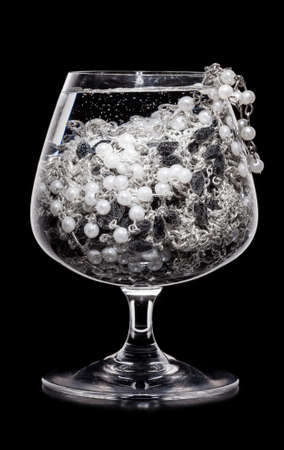 jewelry cocktail. Glass full of various jewelry on black backgroundの写真素材