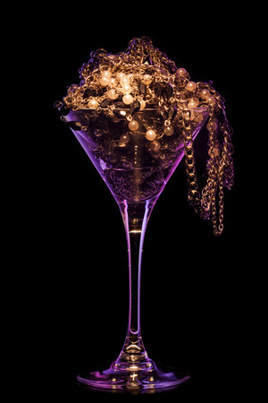 jewelry cocktail. Glass full of various jewelry on black background with smokeの写真素材