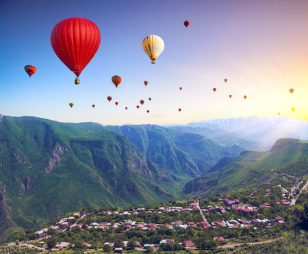 Beautiful landscape with green mountains and air balloons