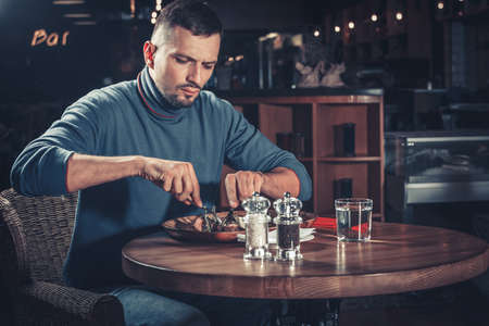 young handsome man eating at the restaurantの写真素材