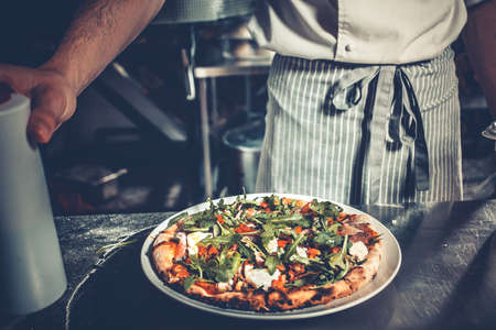 Chef cooking a gourmet tasty pizza close-upの写真素材