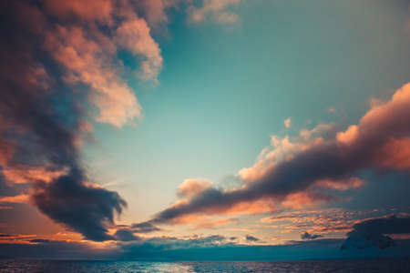 Summer sunset in Antarctica. Coloured Sunset Clouds over ocean with mountains in the background. Beautiful winter landscapeの写真素材
