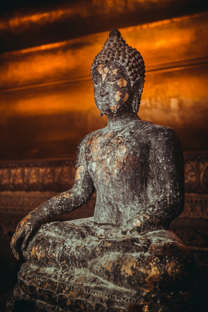 Stone statue of Buddha sitting in lotus pose gold-plated. Thailand, religious temple attraction
