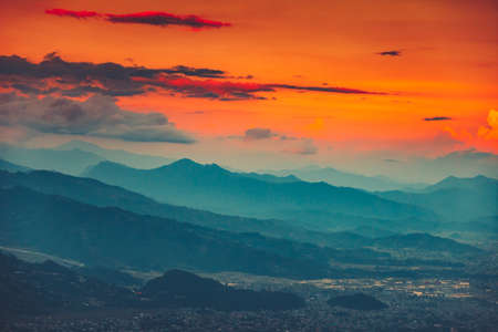 High angle aerial view over Pokhara City, Nepal at evening. Blue mountain misty range and orange sunset cloudy sky in the background. Nature landscape. Travel, holidays, recreation conceptの写真素材