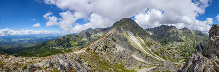 Mountain stone range peak against blue cloudy sky. Nature landscape. Travel background. Holiday, hiking, sport, recreation. National Park High Tatra, Slovakia, Europeの写真素材