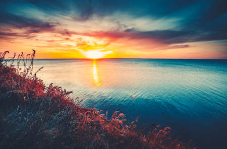 Sunset sky background. Natural Sunset Sunrise Over Ocean. Bright Dramatic Sky And Blue Water. Colorful Nature Landscapeの写真素材