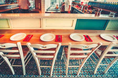 Open Kitchen. Modern and simple cafe interior with wooden furniture - east style mosaic floor,...