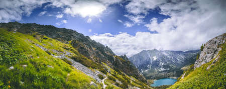 The breathtaking scenery the green valley and the mountain Strbske Pleso lake surrounded by the mighty snow-capped Tatras. The National Park, Slovakia. The beauty of wild virgin nature.の写真素材