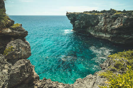 Close-up turquoise bay, vertical cliffs. Indonesia, Sumba island. Spectacular scenery the cozy bay with transparent blue water surrounded by the green-capped cliffs. Indian ocean.の写真素材