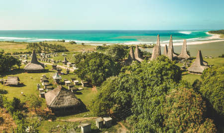 Traditional village. Aerial drone shot. Indonesia. Authentic huts called "ratenggaro" with straw roofs intermingle with tombs in the local settlement, surrounded by the greens. Sumba island.の写真素材