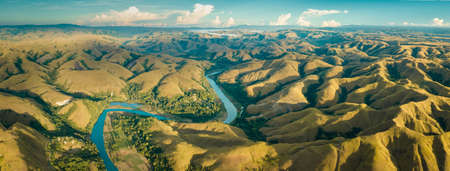 Mountain green hills panorama with curvy river, Merdeka Hill, Bukit Wairinding, East Sumba, Indonesia. Travel Background. Nature landscape. Untouched wild island. Vintage yellow toningの写真素材