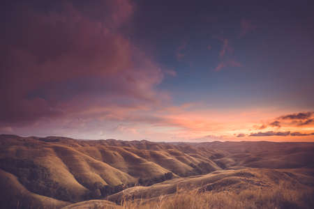 Rainy clouds, sunset sky, hills. Indonesia. Spectacular scene the bright sunset sky over the valley. Perfect background for the different kinds of the collages and illustrations.の写真素材