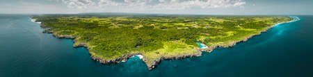 Panorama island, ocean.  Indonesia. Spectacular overview of Sumba island the green-capped plain surrounded by the Indian ocean on the blue cloudy sky background.の写真素材