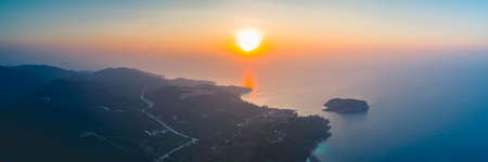 Panorama sunset sky, ocean, island. Breathtaking scene the bright sunset over the calm ocean and Ko Pha-ngan island in the Kingdom of Thailand. Perfect spiritual place.の写真素材