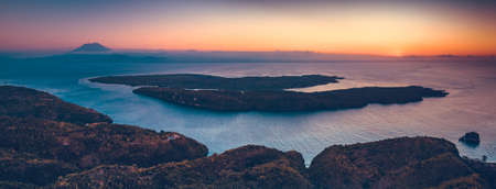 Sunset panorama rview of Indonesia shoreline and ocean. Aerial drone shot of Asian wild nature. Breathtaking landscape. Sunset over the Indonesian land and calm ocean. Bright colorful sky.の写真素材