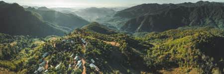 North Thailand wild nature. Aerial drone shot of mountain valley with green covered hills. Overwhelming Asian landscape. Buildings among the wild environment.の写真素材