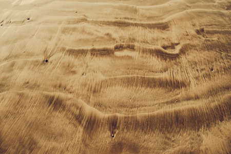 Overview aerial shot of the volcanic sand. Indonesia. Close-up dune waves with the sepia tone. Ideal background, texture for the different kinds of the collages, illustrations and digital media.の写真素材