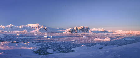Mountain panorama of Antarctica shoreline. Amazing panoramic view. The pieces of the ice floating in the frozen ocean. Breathtaking winter landscape in the blue tints. Travel, nature, destinationの写真素材