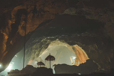 Inside view of the Goa Giri Putri Hindu Temple. Nusa Penida island, Indonesia. The cave interior with the umbrellas, religious attributes. The atmospheric image of the sanctuary.の写真素材