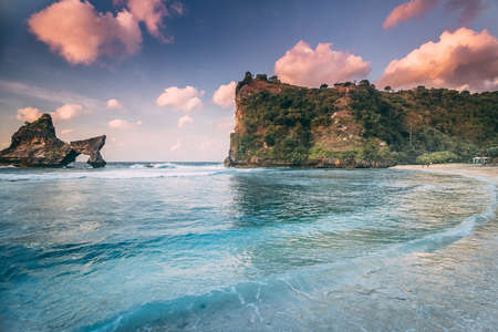 Atuh Beach Nusa Penida Island Coastline Landscape. Seaside Beautiful Tourism Place for Vacation. Panoramic View on on Rock and Ocean Waves. Coastal Scenery in Good Weather Day and Cloudy Skyの写真素材