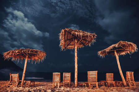 Umbrella and Deckchair Bottle Beach Phangan Island Thailand. Beautiful Coastline Relax Paradise Resort Place, Sea Bay and Starry Cloudy Night Sky. Tropical Exotic Tourist Seaside Sceneryの写真素材