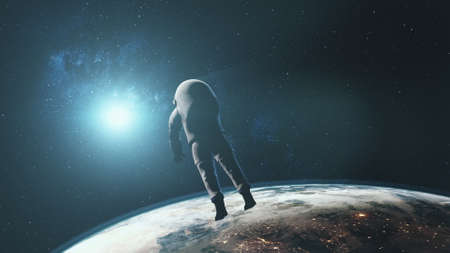 Astronaut against realistic planet Earth starlight. Back view of spaceman in outer space illuminated mainland surface. 3d animation.の写真素材