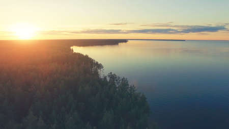 Aerial Drone Flight: above calm Water and forest in sunset soft light. Magestic landscape. Kiev Sea, Ukraine, Europe.の写真素材