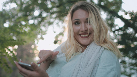 Blonde Girl Talk Hold Smartphone Gesticulation. Happy Pretty Woman Plus Size Use Digital Technology...