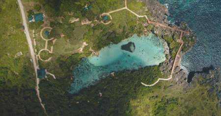 Top down of limpid turquoise lake with designed ways on green valley in aerial view. Nobody Asia nature scenery of Weekuri lagoon, Sumba Island, Indonesia, Asia. Amazing summer landscapeの写真素材