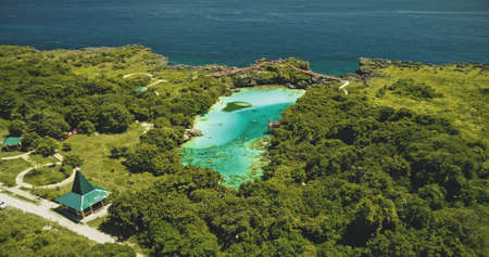 Indonesia landmark of salt water jade lake Weekuri at Sumba Island. Epic resort at limpid loch with natural variety. Amazing architecture attraction with road and cars at green tropic plants, treesの写真素材