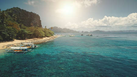 Sun sand beach at green mountain island aerial. Passenger boats at tropic paradise isle nature landscape. Amazing greenery exotic plants and trees. People admire tropical cruiseの写真素材