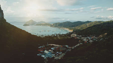 Aerial ocean port with water transport at tropical cityscape. Epic paradise resort with vessels, buildings at summer sun rise in morning. Amazing sunny seascape at El Nido island, Philippines, Asiaの写真素材