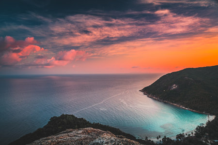 Asia sunset aerial: ocean island highland at Tanote Bay, Koh Tao, Thailand. Amazing Thai skyscape in warm sun set tones on water reflection. Green trees on hills, sand beach at asian lagoonの写真素材
