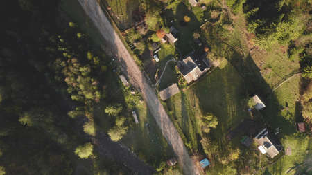 Top down village at mountain valley aerial. Autumn nature landscape. Cottages at rural road. Colorful leafy and pine forest. Cinematic vacation at Carpathian countryside, Ukraine, Europeの写真素材