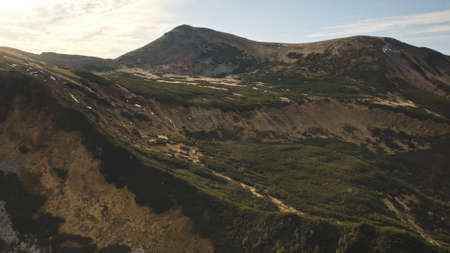 Close up mountain rock top aerial. Green grass, moss at hills, peak. Nobody nature landscape. Autumn greenery meadow, valley at mount ranges. Cinematic tourism to Carpathians ridges, Ukraine, Europeの写真素材