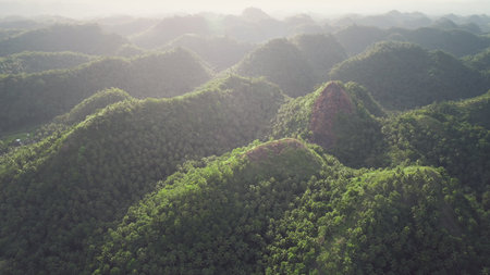 Philippines hills aerial: sun light above mountain ranges. Amazing Asia nature with green forest,...